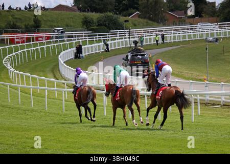 Epsom Downs, Surrey, Inghilterra, Regno Unito. 6 giugno 2025. Corse ippiche Ladies Day a Epsom Downs, Surrey. Cavalli nella Coronation Cup che si dirigono verso la partenza. Il vincitore è stato Jan Brueghel al sesto posto, guidato da Ryan Moore in blu e viola. Prima della gara, il favorito numero 3 Calandagan in verde finì secondo. Crediti: Julia Gavin/Alamy Live News Foto Stock