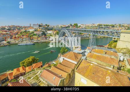 Barche che navigano sotto il fiume Douro a Porto. Vista aerea del ponte Dom Luis i, del lungomare di Ribeira e delle barche Rabelo da Vila Nova de Gaia, Porto, Portug Foto Stock