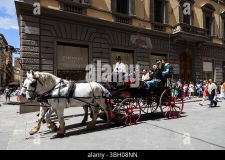 Firenze, Italia - 10 maggio 2025: Carrozza trainata da cavalli con turisti nel centro storico di Firenze Foto Stock