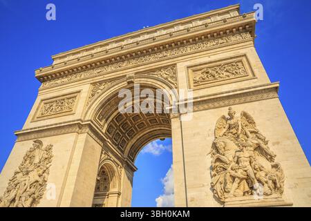 Vista dal basso dell'Arco di Trionfo al centro di Place Charles de Gaulle in una splendida giornata di sole con cielo blu. Famoso punto di riferimento e famoso attrazione turistica Foto Stock
