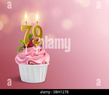 Delizioso cupcake con candele a forma di numero bruciate su sfondo rosa sfumato, spazio per il testo. 79° compleanno o altra occasione speciale Foto Stock
