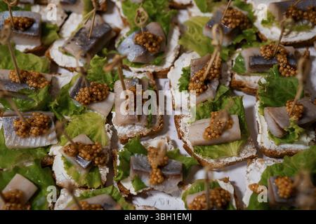 Uno shot ravvicinato presenta tartine di sardine splendidamente placcate, adornate con formaggio cremoso e caviale, presentati come antipasti gourmet, perfec Foto Stock