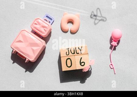 Luglio 6.Calendario di legno con data e orologio da tavolo con campane sul tavolo o ripiano. È estate luglio.alta. Foto Stock