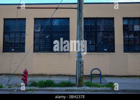 Una serie di vecchie finestre di magazzino accanto a un idrante antincendio a Railtown, Vancouver, British Columbia. Foto Stock