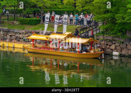 Barca turistica dorata sul fossato del castello di tenshu a Osaka, Giappone Foto Stock