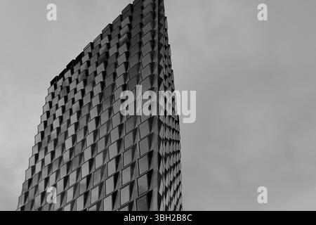 La facciata in vetro riflettente del Pulse nella Zuidas di Amsterdam riflette nuvole mostruose, mescolando un'elegante architettura moderna con una dinamica energia urbana. Foto Stock