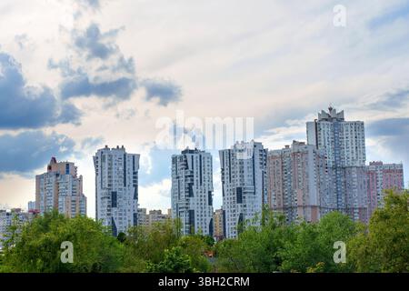 Kiev, Ucraina - 19 maggio 2025: Veduta di diversi edifici moderni e alti nel quartiere Poznyaky di Kiev, circondato dal verde sotto un cl Foto Stock