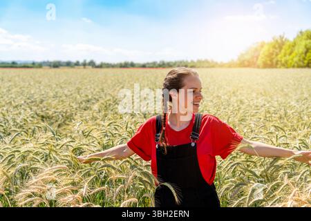 Felice agricoltore che cammina attraverso il campo triticale Foto Stock