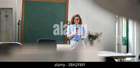 Giovane donna sorridente che usa il cellulare in ufficio utilizzando il cellulare. Foto Stock