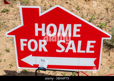SPANISH FORK, UTAH, USA - 8 GIUGNO 2025: Un cartello rosso "Home for sale" viene visualizzato su un lotto di terreno in via di sviluppo di Spanish Fork, Utah, Stati Uniti. Foto Stock