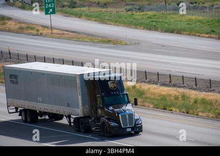 SANTAQUIN, UT – 8 GIUGNO 2025: Il veicolo UPS con rimorchio singolo guida verso nord sulla i-15 vuota. UPS è un'azienda statunitense di spedizioni e logistica fondata nel 1907. Foto Stock