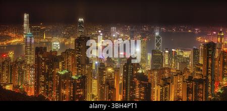 Panorama di Hong Kong, Cina. Spettacolare vista notturna del porto Victoria skyline da Victoria Peak. Il picco è la montagna più alta di Hong Kong ISL Foto Stock