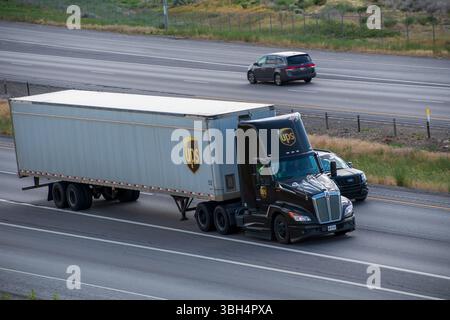 SANTAQUIN, UT – 8 GIUGNO 2025: Un camion UPS con un rimorchio viaggia verso nord sulla i-15 a Santaquin. UPS è un'azienda statunitense di spedizioni e logistica fondata nel 1907. Foto Stock
