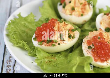 Uova ripiene con caviale di salmone sono un antipasto popolare per ogni occasione. Elegantemente decorate e sapientemente condite, saranno sempre una bella A. Foto Stock