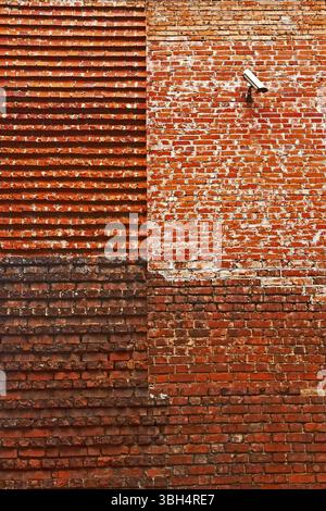 Dettaglio delle mura in mattoni medievali restaurate. Sulla vecchia base costruita su una nuova parte. Telecamera di sorveglianza in alto. Leopoli, Ucraina, Europa Foto Stock