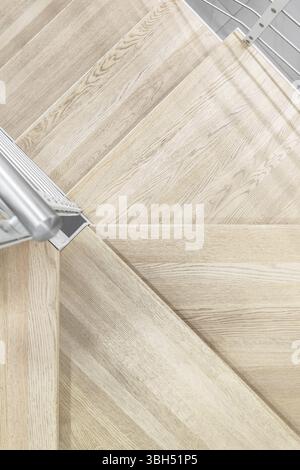 Vista ravvicinata dei gradini in legno naturale. Corrimano in metallo Foto Stock