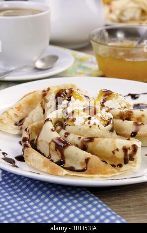 Pancake piegato nella forma di una lumaca per la ricotta con il cioccolato Foto Stock