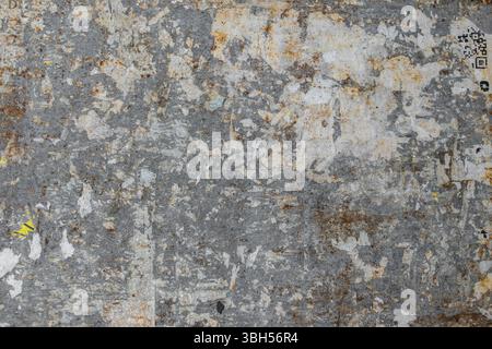 Struttura di un muro grintoso con poster strappati. Ideale per texture e sfondi. Stile retrò Foto Stock