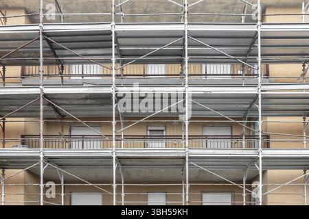 Ponteggio sulla facciata di un edificio a più piani durante il rinnovo della facciata Foto Stock