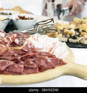 Piatto misto di salumi. Tagliere in legno con prosciutto, pancetta, salame e bresaola. Piatto di carne Foto Stock