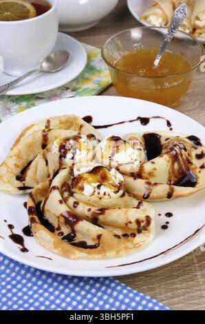 Pancake piegato nella forma di una lumaca per la ricotta con il cioccolato Foto Stock