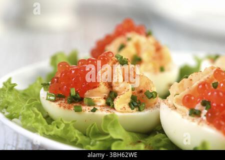 Uova ripiene con caviale di salmone sono un antipasto popolare per ogni occasione. Elegantemente decorate e sapientemente condite, saranno sempre una bella A. Foto Stock