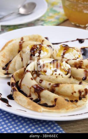 Pancake piegato nella forma di una lumaca per la ricotta con il cioccolato Foto Stock