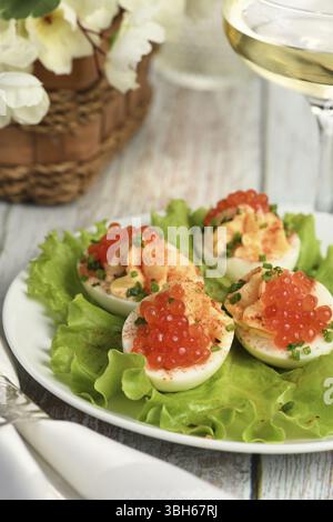 Uova ripiene con caviale di salmone sono un antipasto popolare per ogni occasione. Elegantemente decorate e sapientemente condite, saranno sempre una bella A. Foto Stock