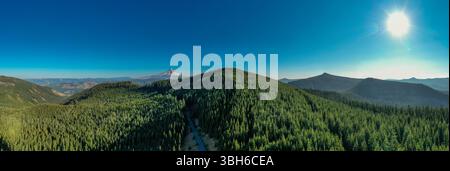 Wahtum Lake, Oregon - 14 agosto 2020: Una vista panoramica di una catena montuosa coperta da foresta con il Monte Hood in lontananza in una giornata limpida e soleggiata. Foto Stock
