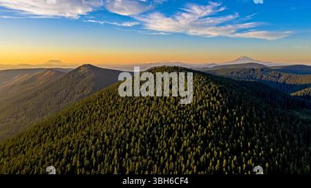 Wahtum Lake, Oregon - 14 agosto 2020: Una vista aerea delle Cascade Mountains, che mostra la fitta foresta e le vette lontane al tramonto. Foto Stock