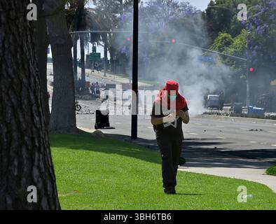 I manifestanti affrontano gli agenti della California Highway Patrol durante una protesta contro I raid di GHIACCIO e immigrazione sulla Alvarado Boulevard Long Beach (710) Freeway a Paramount, California, sabato 7 giugno 2025. L'amministrazione Trump ha detto che avrebbe inviato 2.000 truppe della Guardia Nazionale a Los Angeles dopo un secondo giorno in cui i manifestanti hanno affrontato agenti di immigrazione durante le incursioni delle imprese locali. Foto di Jim Ruymen Foto Stock