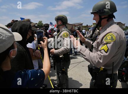 I manifestanti affrontano gli agenti della California Highway Patrol durante una protesta contro I raid di GHIACCIO e immigrazione sulla Alvarado Boulevard Long Beach (710) Freeway a Paramount, California, sabato 7 giugno 2025. L'amministrazione Trump ha detto che avrebbe inviato 2.000 truppe della Guardia Nazionale a Los Angeles dopo un secondo giorno in cui i manifestanti hanno affrontato agenti di immigrazione durante le incursioni delle imprese locali. Foto di Jim Ruymen Foto Stock