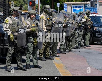 I manifestanti affrontano gli agenti della California Highway Patrol durante una protesta contro I raid di GHIACCIO e immigrazione sulla Alvarado Boulevard Long Beach (710) Freeway a Paramount, California, sabato 7 giugno 2025. L'amministrazione Trump ha detto che avrebbe inviato 2.000 truppe della Guardia Nazionale a Los Angeles dopo un secondo giorno in cui i manifestanti hanno affrontato agenti di immigrazione durante le incursioni delle imprese locali. Foto di Jim Ruymen Foto Stock