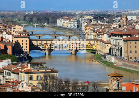Vista aerea del Ponte Vecchio sul fiume Arno perfettamente illuminato dal sole e da altri edifici storici di firenze in ITALIA Foto Stock