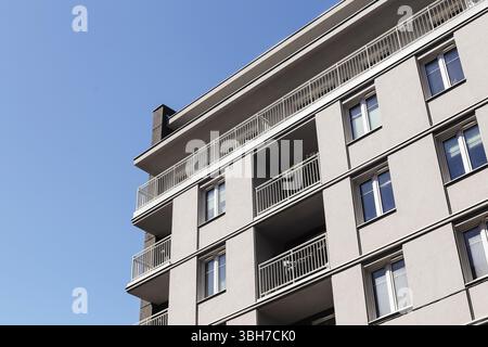 Facciata di un edificio residenziale grigio. Balconi abitativi urbani. Contesto degli investimenti immobiliari. Muro esterno dell'appartamento. Moderna architettura cittadina. Foto Stock