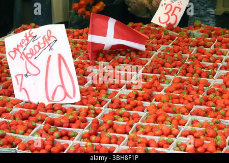 Scatole con fragole danesi con etichetta del prezzo scritta in danese per la vendita in una stalla di mercato. Foto Stock