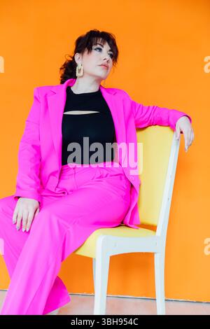 Ritratto di una bella donna bruna alla moda e sottile in un abito da lavoro cremisi Foto Stock