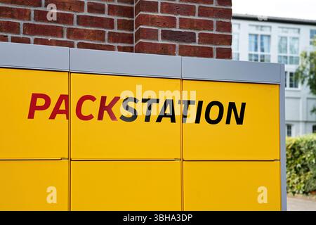 Colonia, Germania 08 giugno 2025: DHL Packstation con il logo "PACKSTATION" in un ambiente urbano o periferico Foto Stock
