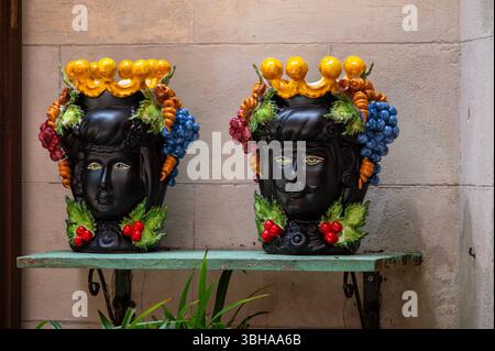 Arte popolare siciliana, vasi di fiori tradizionali a forma di teste di uomo e donna, colorate ceramiche dipinte a mano, splendido souvenir per i turisti Foto Stock