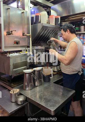 Preparare il tè al latte in stile HK al LAN Fong Yuen è una famosa casa di tè al latte in stile Hong Kong in Gage Street a Hong Kong. Foto Stock