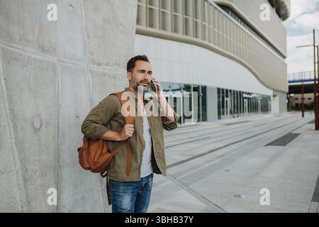 Ritratto di un uomo di mezza età che fa una telefonata all'aperto. Foto Stock