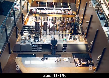 Vista dall'alto della Starbucks Reserve Roastery di Chicago, caratterizzata da design industriale, silos di caffè, baristi moderni al lavoro e birre di prima qualità Foto Stock