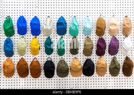Vendita di cappellini da baseball multicolore al banco espositore di un negozio. Foto Stock