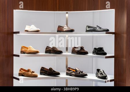 Scaffali per il deposito di vestiti e accessori. Ripiani con eleganti scarpe da uomo. Molte scarpe e stivali classici. Tonificante marrone. Splendido display Foto Stock