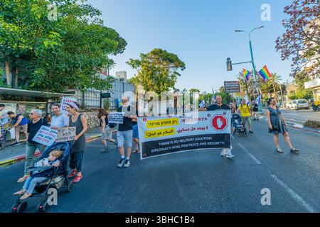 Haifa, Israele - 7 giugno 2025: Le persone prendono parte a una marcia di protesta (gruppo di attivisti per la pace), con vari segni e bandiere, chiedendo la fine della guerra, e. Foto Stock