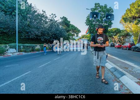 Haifa, Israele - 7 giugno 2025: Le persone prendono parte a una marcia di protesta (portavoce), Haifa, Israele Foto Stock