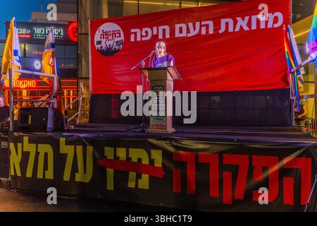 Haifa, Israele - 7 giugno 2025: L'attivista Eliah Levin parla alla folla, parte di una manifestazione di protesta che chiede la fine della guerra, il completamento Foto Stock