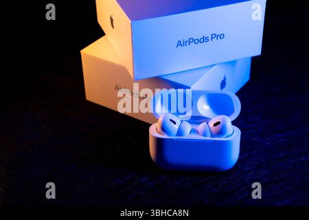 Jurmala, Lettonia - 01.05.2025: Primo piano nuove cuffie Apple - AirPods Pro 2. Auricolari wireless di alta qualità nella custodia di ricarica, visualizzati con la confezione Foto Stock
