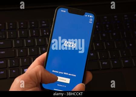Persona che utilizza l'app NHS su un iphone Foto Stock