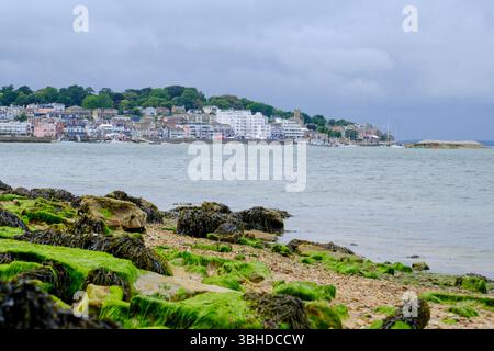 07 giu 2025 - Cowes, Isola di Wight - Una vista di Cowes, Isola di Wight, dall'altra parte della costa in una tipica giornata piovosa e piovosa. Foto Stock